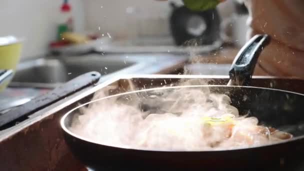 Cocine poner hojas de albahaca en espaguetis con salsa de tomate rojo en la sartén . — Vídeo de stock