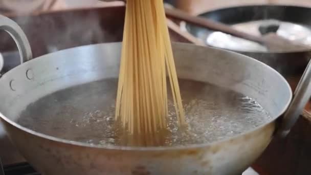 Добавьте спагетти в кипящую воду. Вентиляторная композиция, крупным планом — стоковое видео