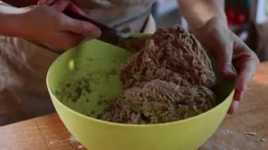 Genç kadın için yeşil plastik kabın içinde ev yapımı ekmek hamur yoğurma