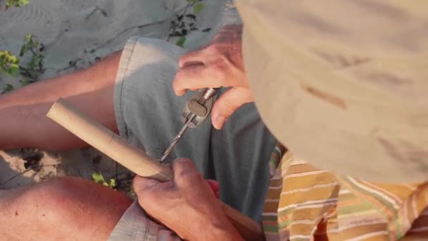 Senior-Mann sitzt am Strand und macht Flöte mit den Händen, Nahaufnahme. — Stockvideo