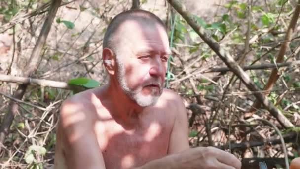 Seniorchef spricht und zeigt, wie man Bambusflöte mit der Hand herstellt — Stockvideo