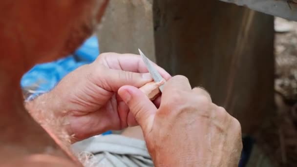 Hombre mayor corta el corcho para hacer una flauta de mano, primer plano — Vídeos de Stock