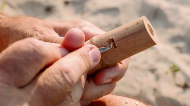 Komuta sizde oturur plaj ve yapım flüt üzerinde eller tarafından yakın çekim.