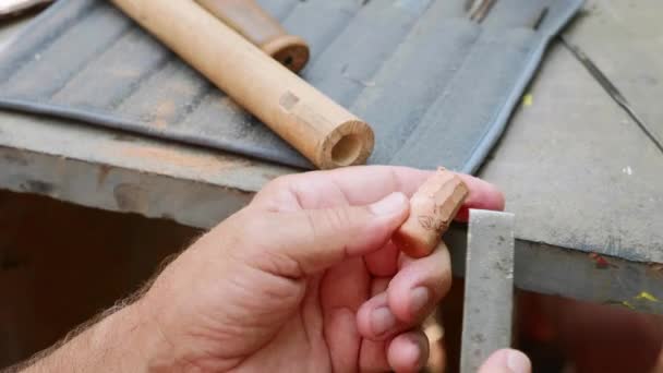 Senior uomo macina il tappo di sughero per file per fare un flauto a mano, primo piano — Video Stock