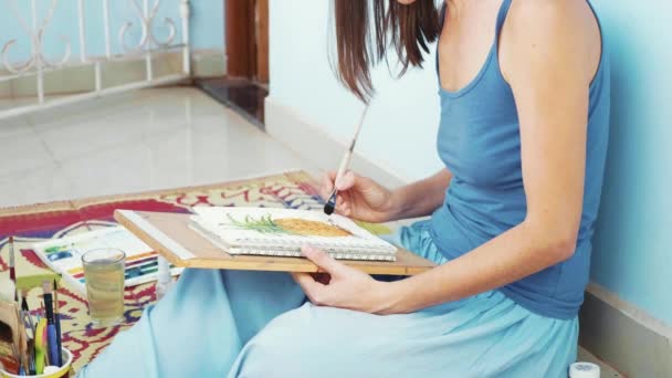 Jovem artista feminina pintando um abacaxi por aquarelas — Vídeo de Stock