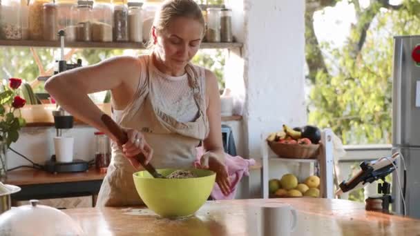 Молодая женщина месит тесто для домашнего хлеба в зеленой пластиковой миске — стоковое видео