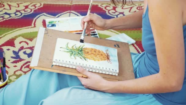 Молода художниця малює ананас акварелями — стокове відео