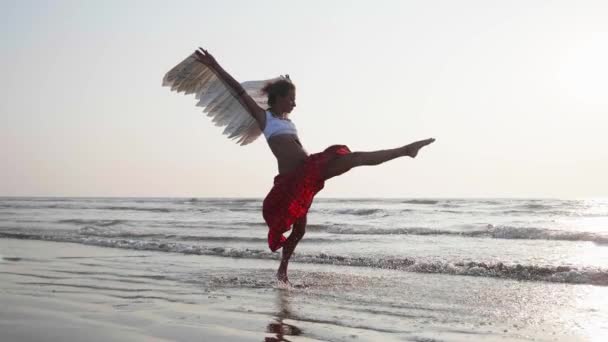 Chica joven con alas de ángel bailando al atardecer — Vídeos de Stock