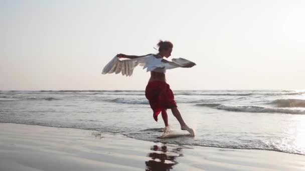 Young girl with angel wings dancing at sunset — Stock Video