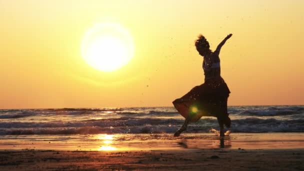 Silhuetten av ung flicka dansa vid solnedgången i slow motion — Stockvideo