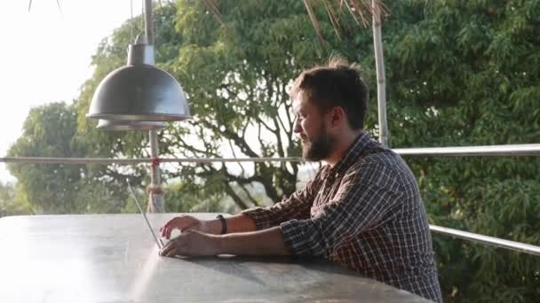 Hombre barbudo guapo apertura portátil y comenzar a trabajar al aire libre — Vídeos de Stock