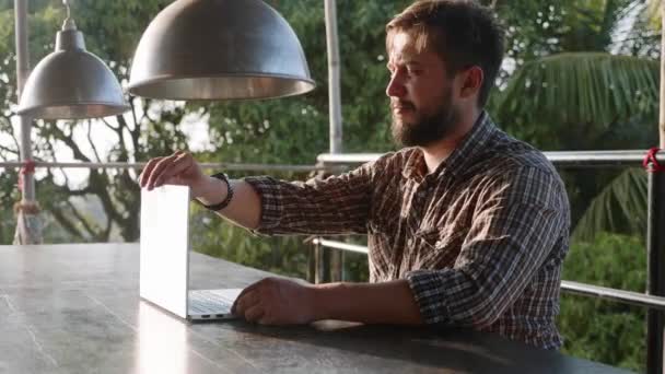 Hombre barbudo guapo apertura portátil y comenzar a trabajar al aire libre — Vídeo de stock