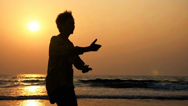 Tai chi jimnastik kum plajındaki pratik etkin üst düzey kadın silüeti. — Stok fotoğraf