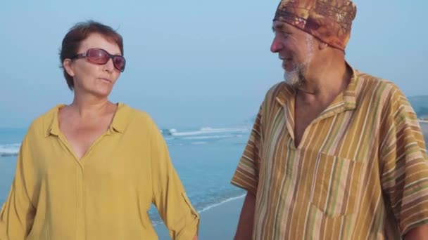 Seniorpaar geht am Strand spazieren und spricht, Steadicam-Aufnahme — Stockvideo