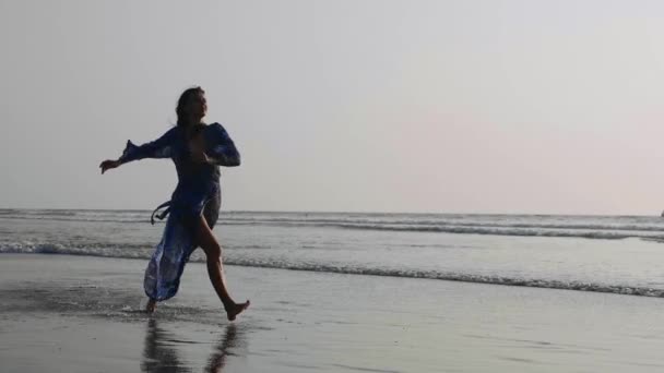 Jonge vrouw presterende grand jete springen op het strand in slow motion — Stockvideo