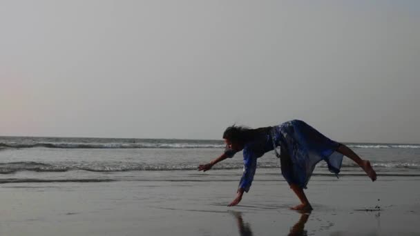 Young gymnast woman doing handspring on sandy beach — Stock Video