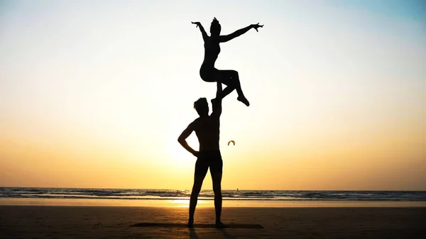 Sportif kaç ortakla birlikte kum plajındaki Acro yoga uygulamak uygun. — Stok fotoğraf