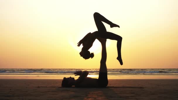 Passa sportig par öva acro yoga med partner tillsammans på sandstranden. — Stockvideo