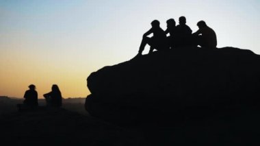 Siluet grup günbatımı dağın zirvesinde hayran insan