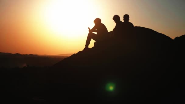 Σιλουέτα ομάδα ανθρώπων θαυμάζοντας το ηλιοβασίλεμα στην κορυφή του βουνού — Αρχείο Βίντεο