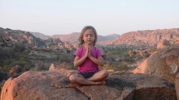 Niña linda meditando en la cima de la montaña . — Vídeo de stock