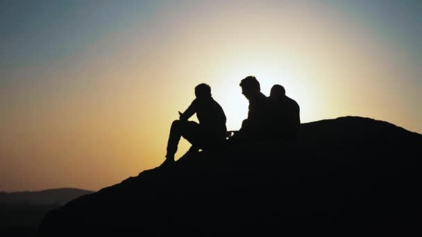 Silueta grupo de personas que admiran la puesta de sol en la cima de la montaña — Vídeo de stock