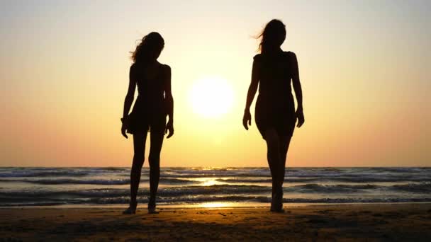 Silueta de mujeres jóvenes deportistas practicando elemento de baile en la playa . — Vídeos de Stock