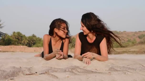 Moeder en tiener dochter samen op het zandstrand liggen, praten en lachen — Stockvideo