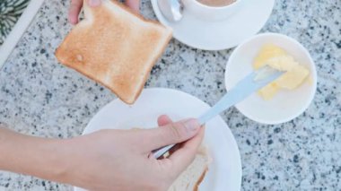 Kadın kahvaltı için tereyağı yapma sandviç ile tost masa bıçağı yağ olduğunu.