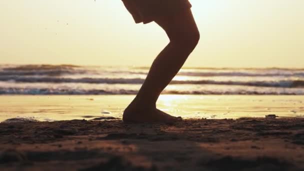 Silueta dívčích nohou poskakuje po laně na mořské písečné pláži při západu slunce. — Stock video