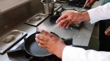 Cook küçük bir metal kase içinde bir masala omlet hazırlar, bir çatal ile yumurta karışımları.