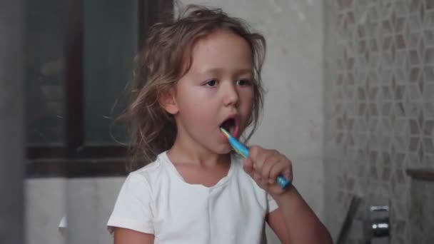 Küçük çocuk kız banyoda diş fırçası ile dişlerini fırçalıyor. — Stok video