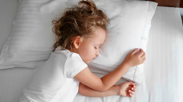 Маленькая милая девочка спит в постели по утрам . — стоковое фото