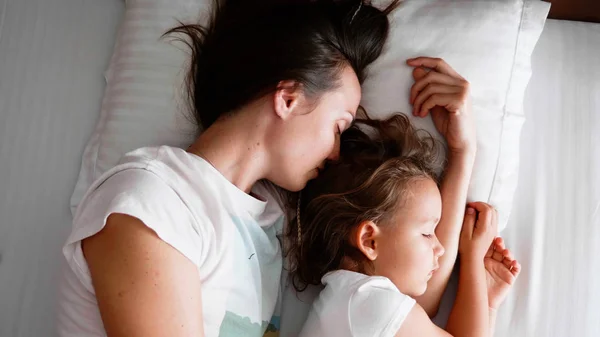 Молодая мама спит со своей милой маленькой дочкой . — стоковое фото