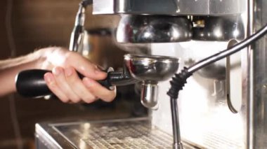 Adam barista kahve makinesinde kahve hazırlıyor.