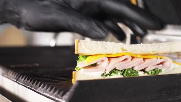 Chef-kok is koken sandwich op een elektrische grill in een fast food restaurant. — Stockvideo