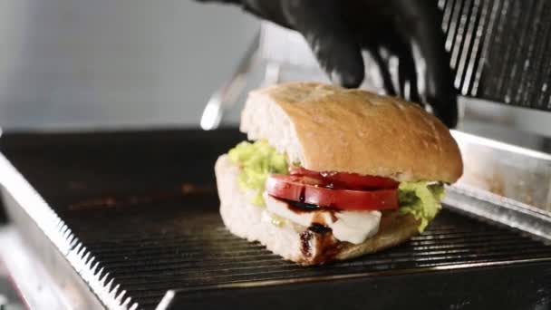 Sandwich de cuisine sur un gril électrique dans un restaurant fast food, vue rapprochée . — Video