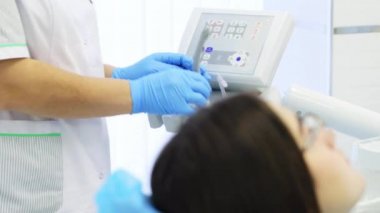 Diş hekimi genç kadın hastanın bir diş delme olduğunu.