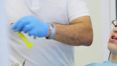 Diş hekimi genç kadın hasta için diş dolgular yapar.