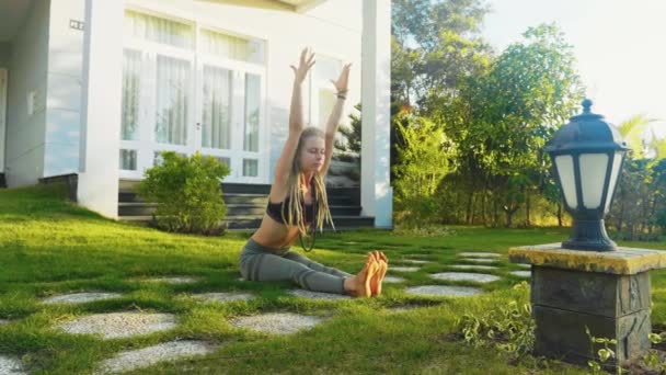 Young woman is doing yoga practice exercise on the backyard of her house. — 비디오