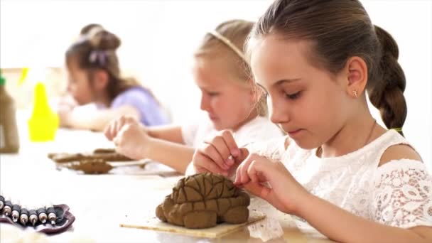 Barn flickor gör leksaker från våt lera med särskilda verktyg i konst verkstad. — Stockvideo