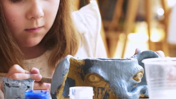 Kindermädchenfarben in blau ihre handgemachte Elefantenschale aus Ton in der Kunstwerkstatt. — Stockvideo