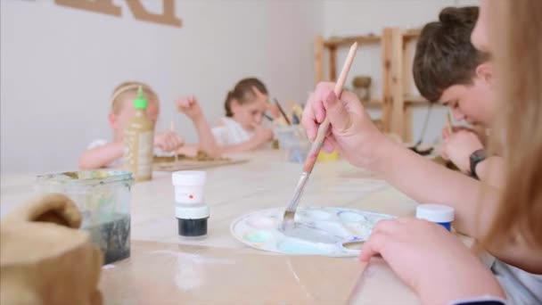 Los niños en la lección de arte en la escuela primaria están pintando y esculpiendo de arcilla — Vídeos de Stock