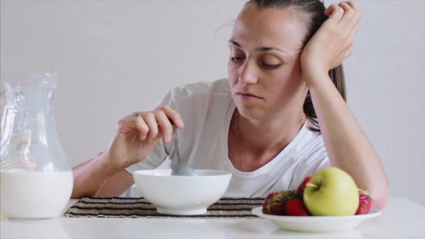 Uykulu yorgun genç kadın kahvaltı, süt ile Mısır gevreği yemek istemiyorum. — Stok video