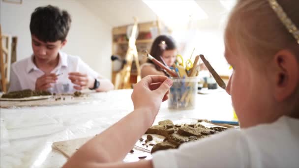 Lección de arte en taller con niños para esculpir de arcilla en la escuela primaria — Vídeos de Stock