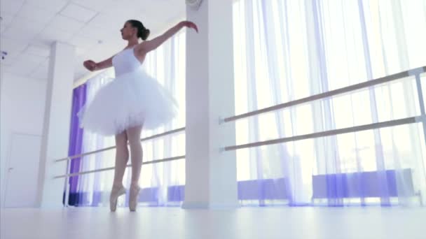 Jovem bailarina em tutu branco e pointes girando em dança na aula de balé . — Vídeo de Stock