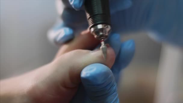 Pedicurist Master in blauwe handschoenen maakt hardware pedicure in schoonheidssalon. — Stockvideo