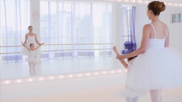 Teacher and little girl are training ballet steps near the mirror on dance class — Stock Video