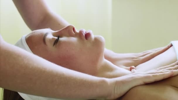 Mujer joven disfruta de masaje facial en salón de spa de belleza en el tratamiento de bienestar . — Vídeos de Stock