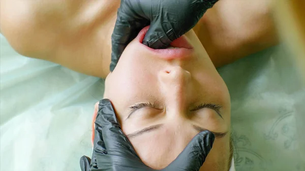 Fisioterapista sta facendo massaggio facciale lavorando sulla mascella delle donne in clinica di bellezza Fotografia Stock